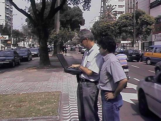 Guirardi (com o notebook) e Paulo demonstram o sistema, no canteiro central da avenida Ana Costa, em Santos