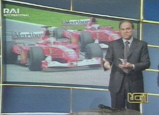 No tel�o, a pol�mica ultrapassagem, e o comentarista da televis�o italiana RAI International expressa sua indigna��o (Imagem: 12/5/2002)