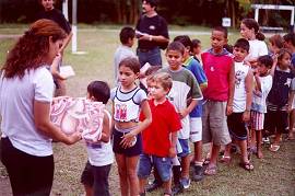 Crian�as fazem fila para receber os livros